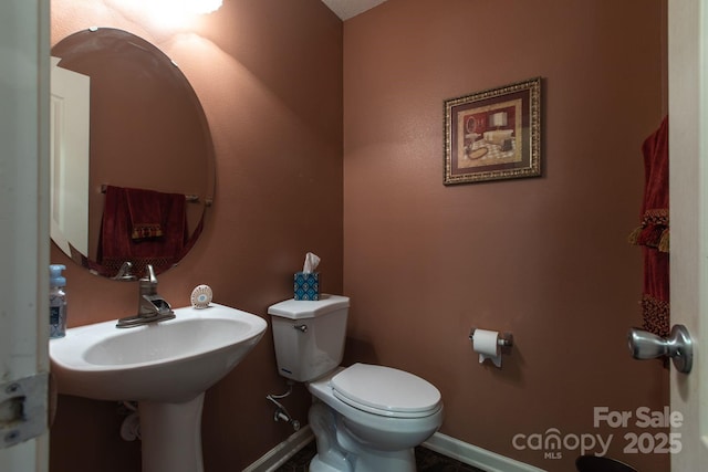 bathroom with baseboards and toilet