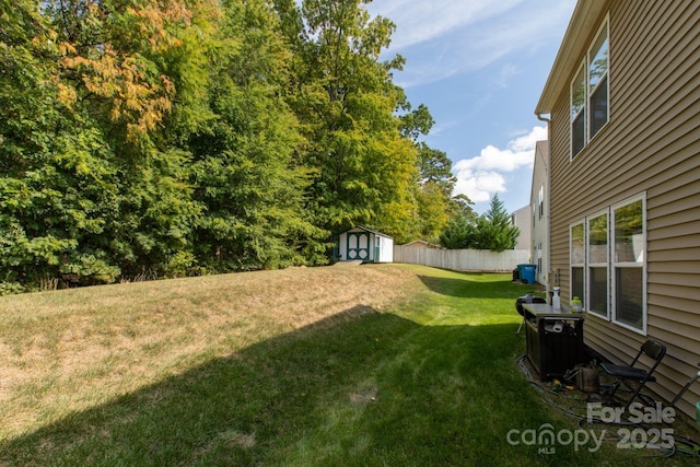 view of yard featuring an outdoor structure, fence, and a shed