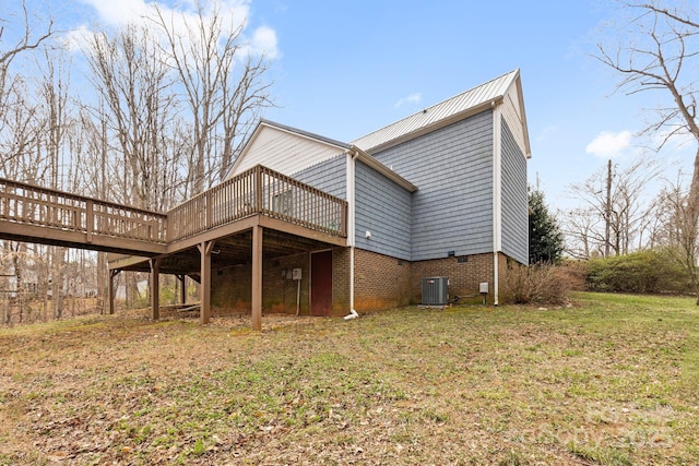 exterior space featuring a deck, a lawn, and central AC