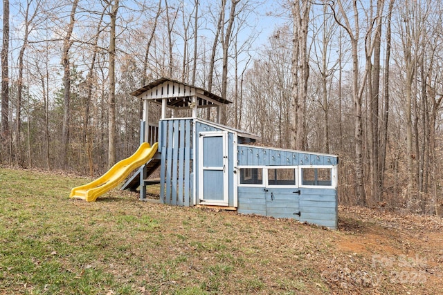 view of jungle gym featuring a view of trees