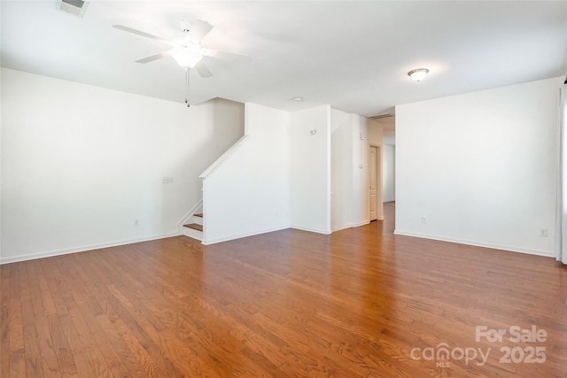 spare room with visible vents, baseboards, stairs, wood finished floors, and a ceiling fan