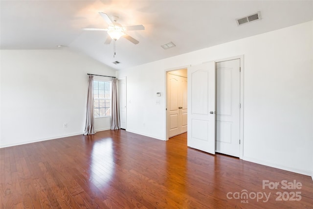 spare room with wood finished floors, baseboards, visible vents, ceiling fan, and vaulted ceiling