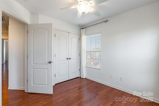 unfurnished bedroom with ceiling fan, a closet, baseboards, and wood finished floors