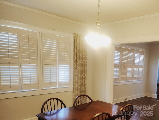 dining room with crown molding, wood finished floors, and baseboards