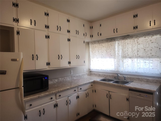 kitchen with white cabinetry, white appliances, light countertops, and a sink