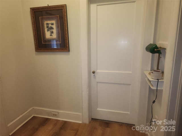 hallway with wood finished floors and baseboards