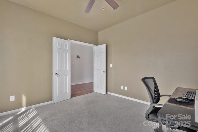 unfurnished office featuring carpet, baseboards, and ceiling fan