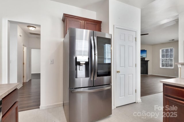 kitchen with visible vents, a fireplace, stainless steel fridge with ice dispenser, and light wood-style flooring