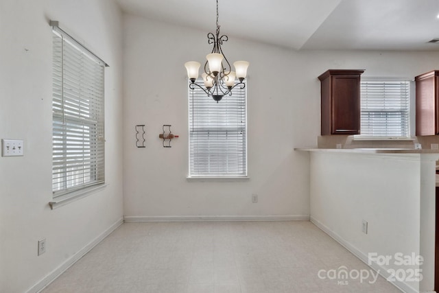 unfurnished dining area featuring a chandelier, plenty of natural light, light floors, and baseboards