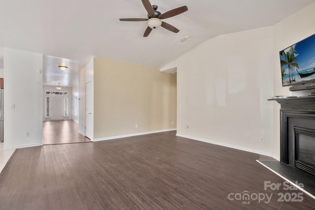 unfurnished living room featuring a ceiling fan, a glass covered fireplace, wood finished floors, baseboards, and vaulted ceiling