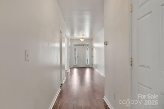 hall with dark wood-style floors and baseboards