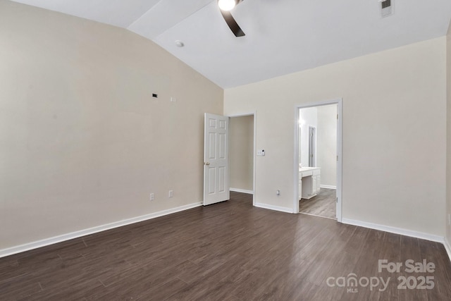 unfurnished bedroom with baseboards, visible vents, dark wood-type flooring, vaulted ceiling, and ensuite bathroom