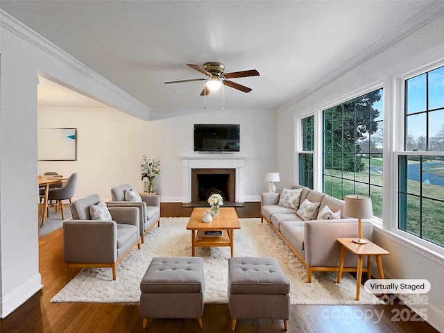 living area with plenty of natural light, wood finished floors, and crown molding