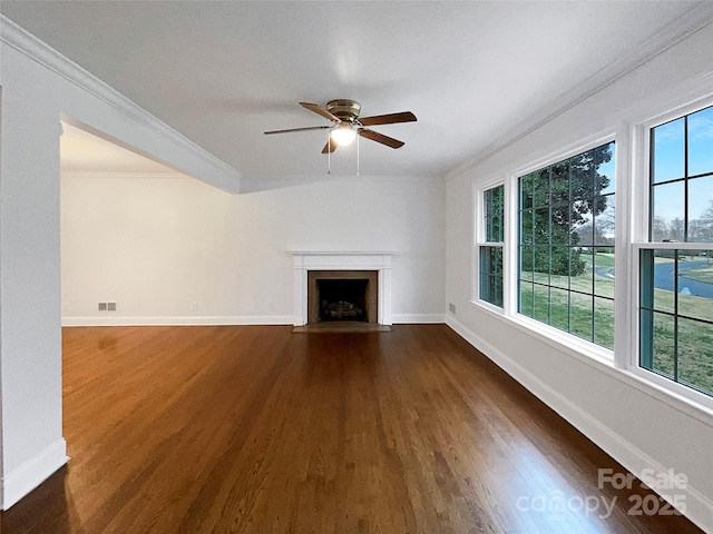 unfurnished living room with dark wood finished floors, a fireplace with flush hearth, crown molding, and visible vents