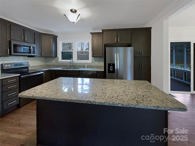 kitchen with a sink, light stone countertops, backsplash, and stainless steel appliances