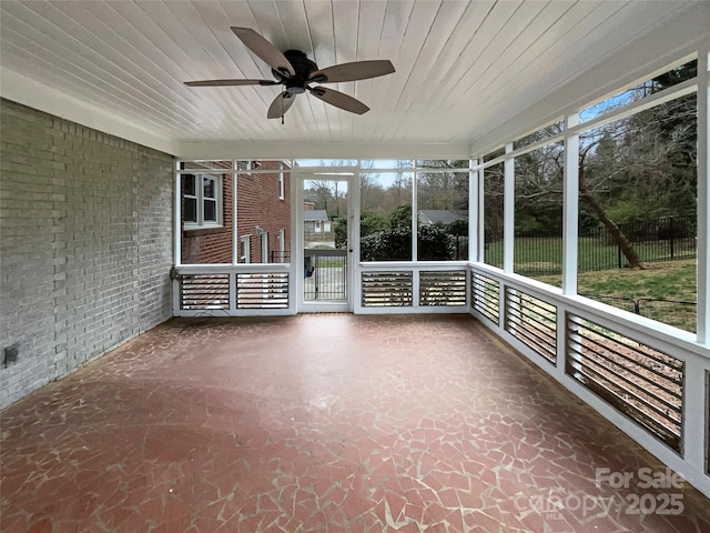 unfurnished sunroom with wood ceiling and ceiling fan