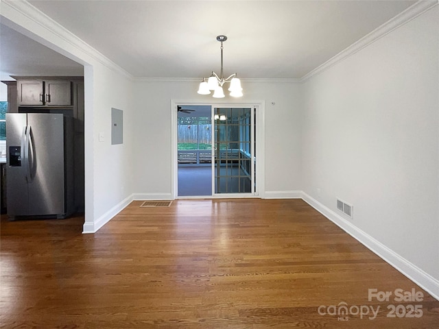 unfurnished dining area featuring electric panel, wood finished floors, a chandelier, and ornamental molding