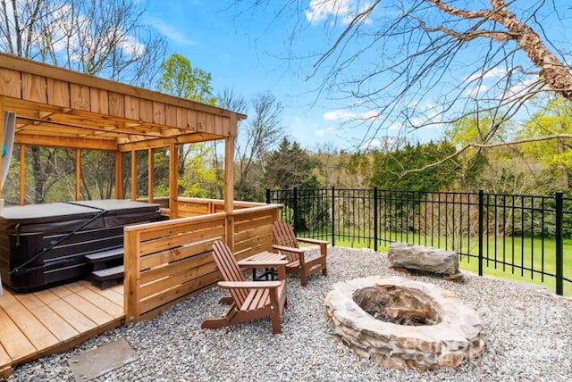 deck with a fire pit, a hot tub, and fence