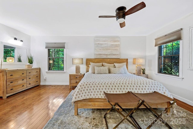 bedroom with a ceiling fan, baseboards, and wood-type flooring