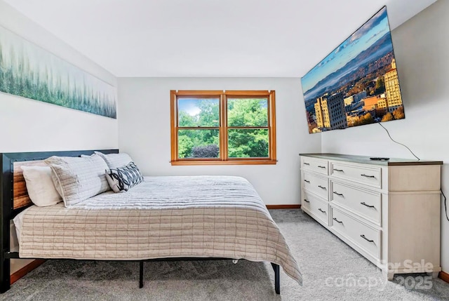 bedroom featuring light colored carpet and baseboards