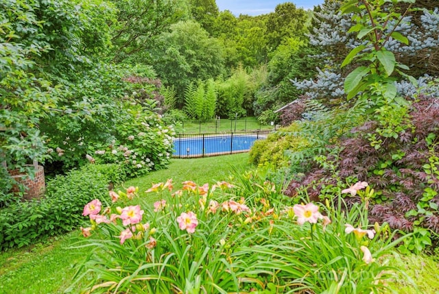 view of yard with a fenced in pool and fence