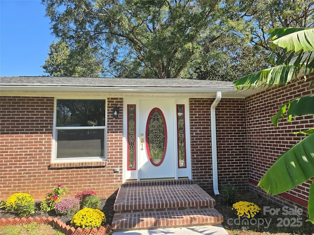 property entrance featuring brick siding