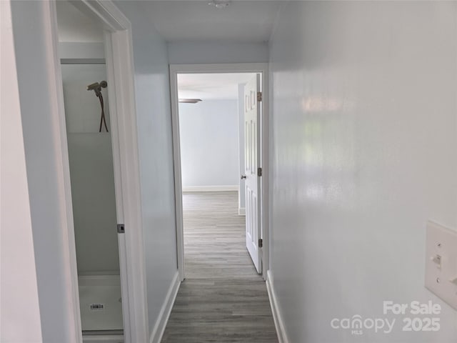 corridor with baseboards and dark wood-type flooring