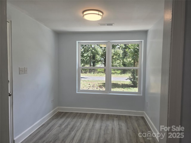 empty room with a healthy amount of sunlight, visible vents, and baseboards