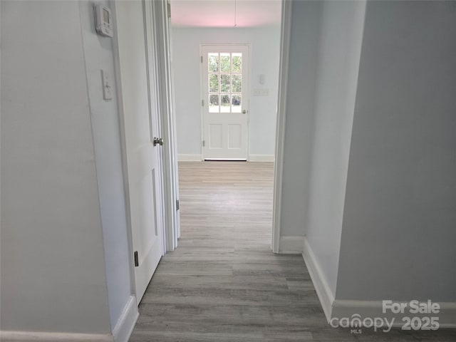 corridor with wood finished floors and baseboards