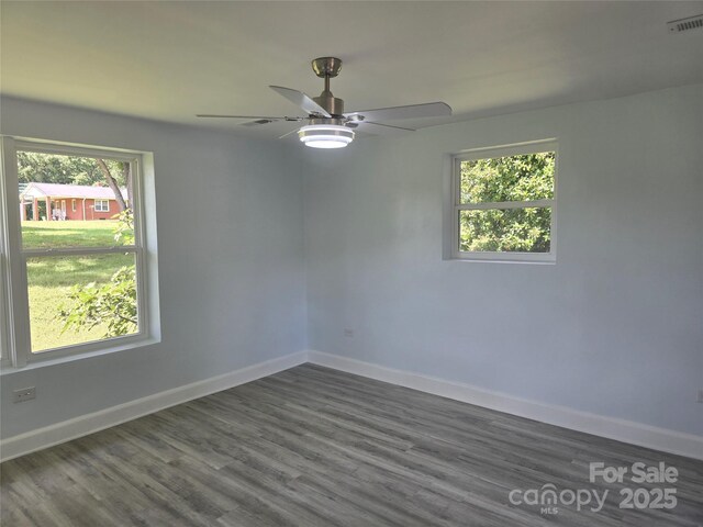 unfurnished room featuring visible vents, baseboards, ceiling fan, and dark wood-style flooring