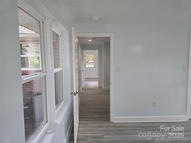 hallway featuring baseboards and wood finished floors