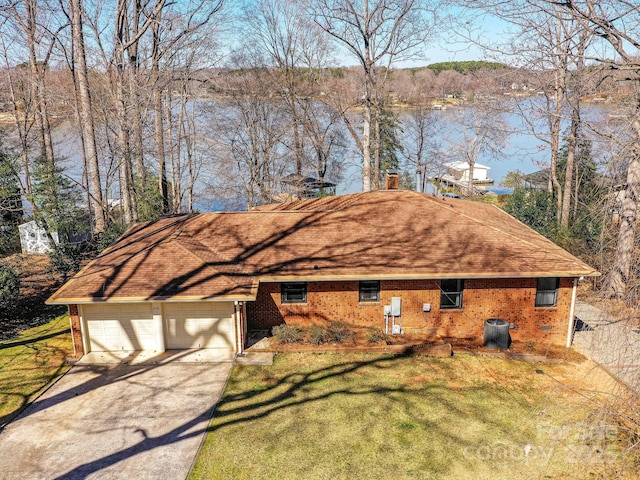 view of side of property with brick siding, a lawn, an attached garage, and concrete driveway