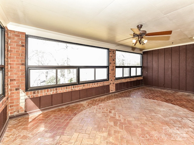 unfurnished sunroom featuring ceiling fan