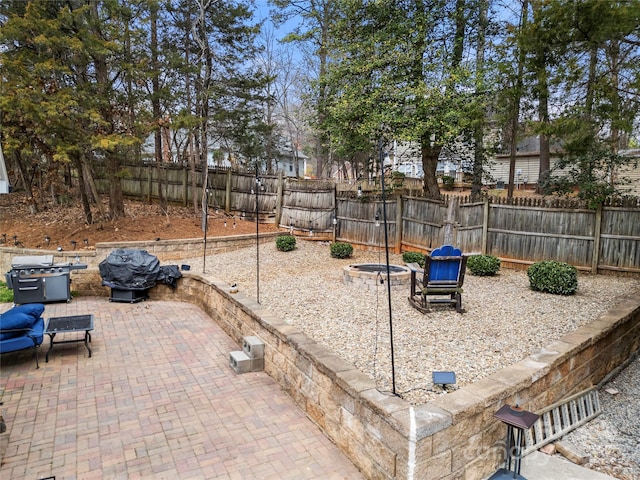 view of jungle gym with a patio area, a fenced backyard, and an outdoor fire pit