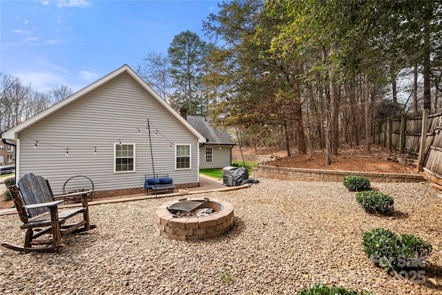 back of house with fence and an outdoor fire pit