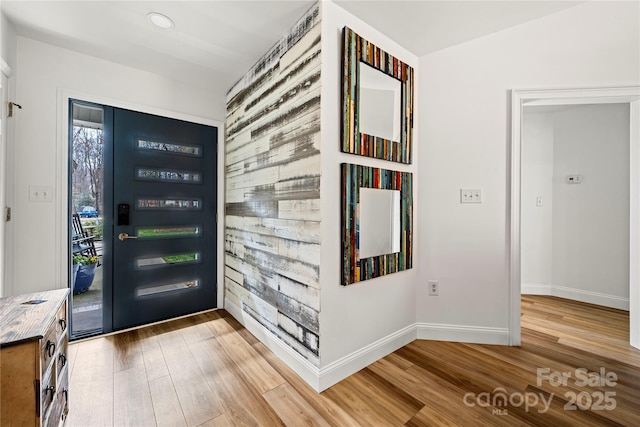 foyer entrance featuring baseboards and light wood-style floors