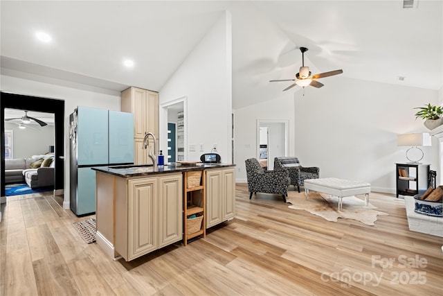 kitchen with a ceiling fan, cream cabinets, open floor plan, freestanding refrigerator, and light wood-style floors