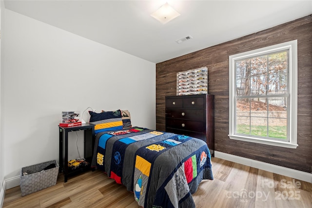 bedroom featuring visible vents, baseboards, and wood finished floors