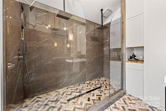 bathroom featuring a marble finish shower