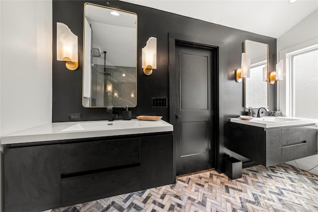 bathroom with walk in shower, two vanities, lofted ceiling, and a sink