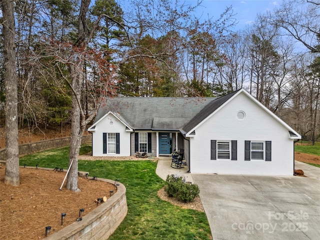 single story home featuring brick siding, roof with shingles, concrete driveway, and a front yard