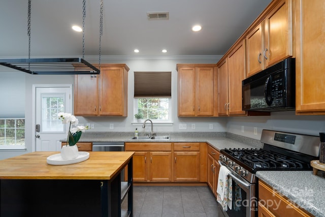 kitchen featuring visible vents, wooden counters, a sink, appliances with stainless steel finishes, and crown molding