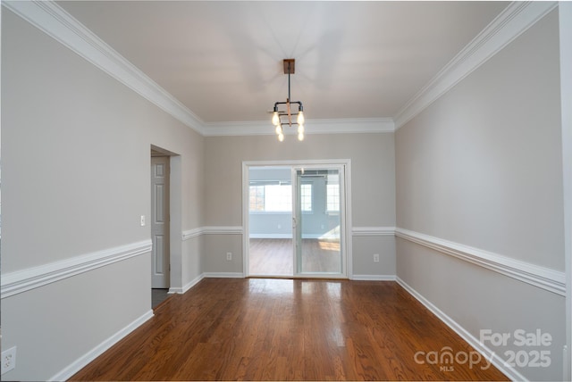 unfurnished dining area with baseboards, wood finished floors, a chandelier, and crown molding