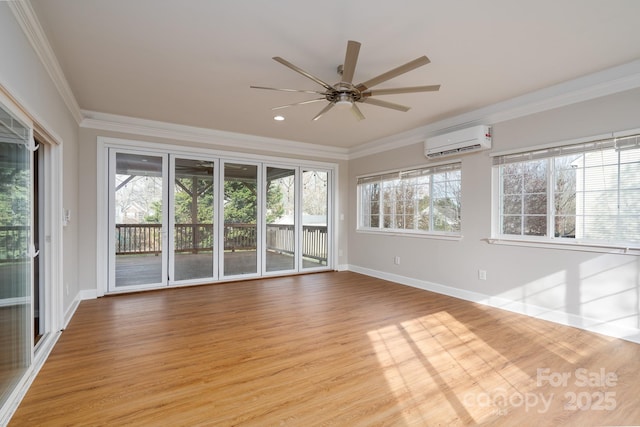 unfurnished room with an AC wall unit, ornamental molding, a ceiling fan, light wood-style floors, and baseboards