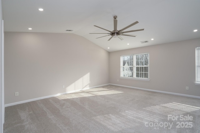 empty room featuring visible vents, a ceiling fan, baseboards, carpet flooring, and lofted ceiling