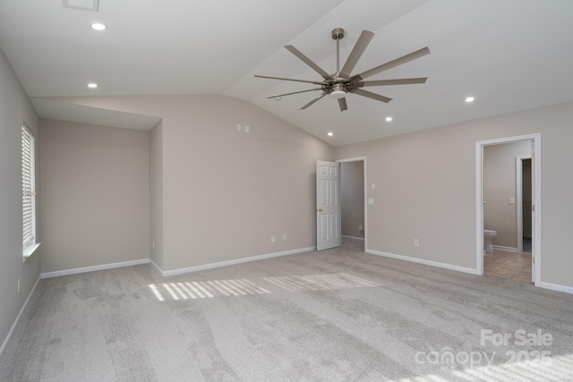 unfurnished bedroom featuring baseboards, lofted ceiling, light carpet, recessed lighting, and ensuite bathroom