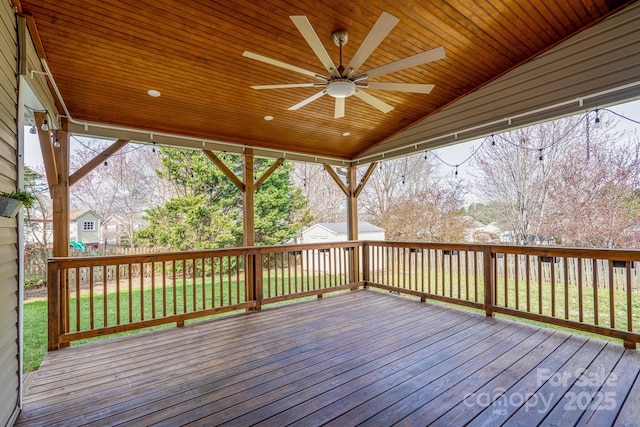 wooden deck featuring an outbuilding, a storage unit, a lawn, and ceiling fan