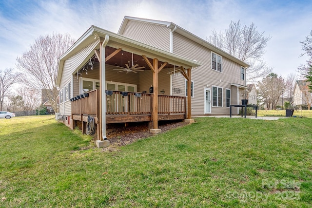 rear view of property featuring a deck, a lawn, and ceiling fan