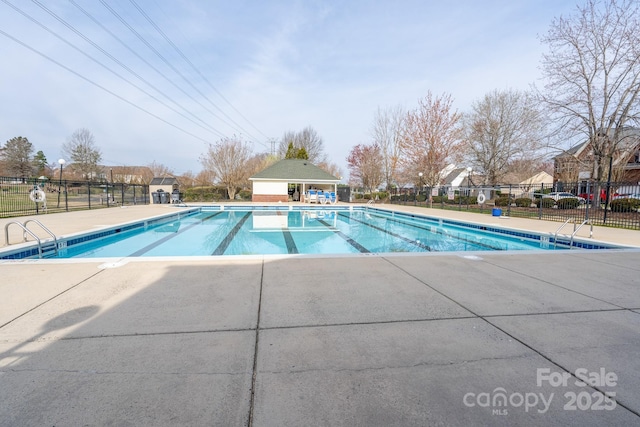 pool with a patio area and fence