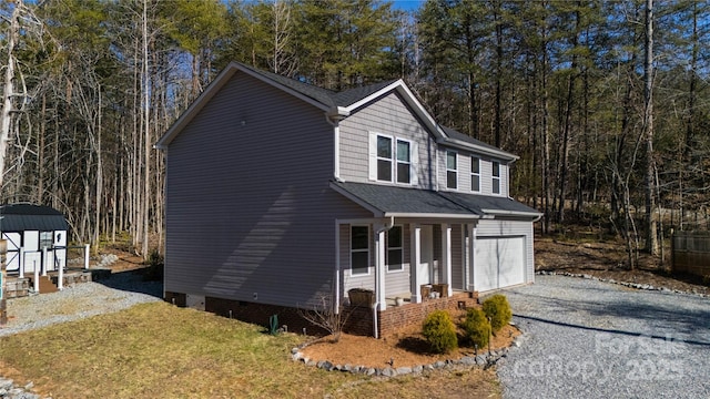 view of front facade with a forest view, driveway, a porch, an attached garage, and a storage shed